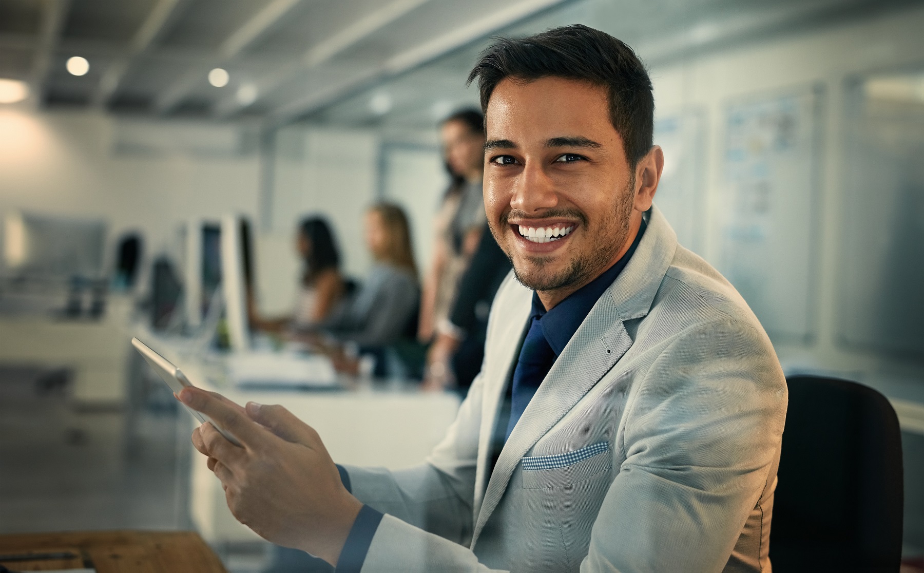 Portrait of a young businessman using a digital tablet in an office.